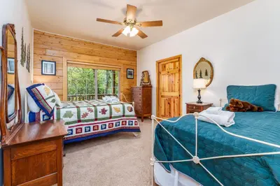 a bedroom with two beds and a mirror at Bass Lake Log Home - Dog Friendly in Bass Lake