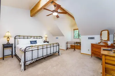 a bedroom with a bed and a ceiling fan at Bass Lake Log Home - Dog Friendly in Bass Lake