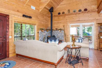 a living room with a couch and a fireplace at Bass Lake Log Home - Dog Friendly in Bass Lake