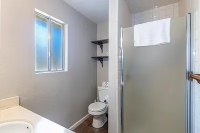 a white bathroom with a toilet and a sink at Starry Pines- Pet friendly/spa/affordable in Oakhurst