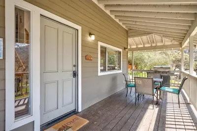 a porch with a white door and a table and chairs at Selah Cabin- Dog Friendly/BBQ/Level 2 EV Charger in Oakhurst
