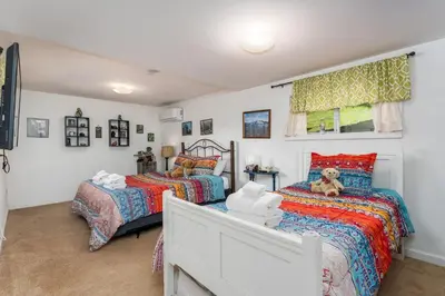 a bedroom with two beds and a teddy bear on the bed at Selah Cabin- Dog Friendly/BBQ/Level 2 EV Charger in Oakhurst