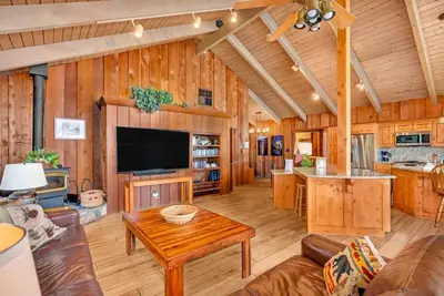 a living room with a television and a table in a cabin at Eagles Nest at Bass Lake near Yosemite with Boat Dock in Bass Lake
