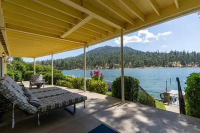 a porch with a couch and a view of a lake at Eagles Nest at Bass Lake near Yosemite with Boat Dock in Bass Lake