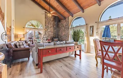 a living room with a couch and a table at River View Retreat Sleeps 16/ hot tub/basketball court in Oakhurst