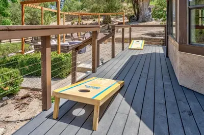 a wooden bench sitting on top of a deck at River View Retreat Sleeps 16/ hot tub/basketball court in Oakhurst