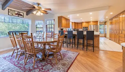 a dining room and kitchen with a table and chairs at River View Retreat Sleeps 16/ hot tub/basketball court in Oakhurst