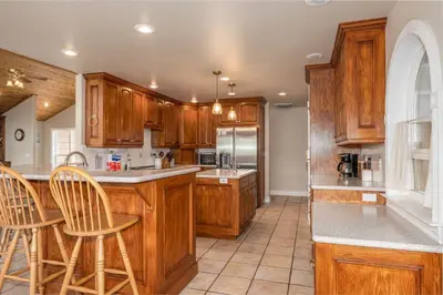 a kitchen with wooden cabinets and a counter top at Yosemite Adventure House with Pool-hot tub-game room in Oakhurst