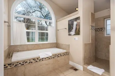 a bathroom with a tub and a window at Yosemite Adventure House with Pool-hot tub-game room in Oakhurst