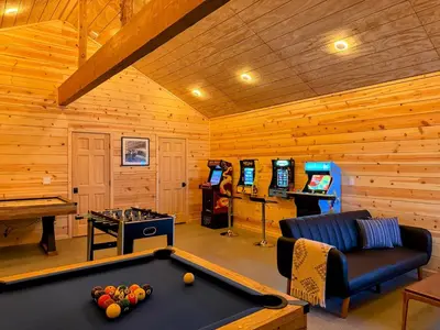 a living room with a pool table and video games at Log Cabin w/ pool, spa, game room, sleeps 20 in Coarsegold