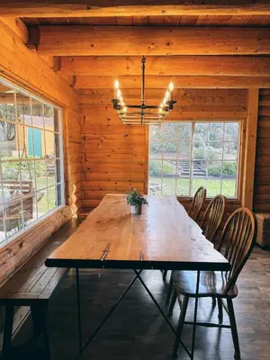 a dining room with a wooden table and chairs at Log Cabin w/ pool, spa, game room, sleeps 20 in Coarsegold