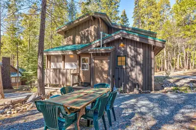 a table and chairs in front of a tiny house at Place to Call Home - Cabin INSIDE Yosemite - Dog Friendly in South Wawona