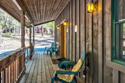 a porch of a house with chairs and a table at Place to Call Home - Cabin INSIDE Yosemite - Dog Friendly in South Wawona