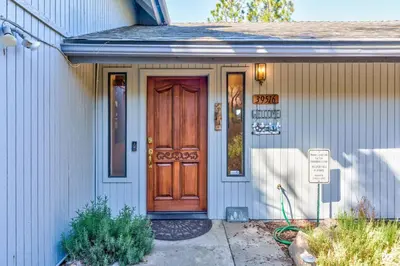 a house with a wooden door on it at Stimboli Lodge- Sleeps 16 with tons of games and fun in Oakhurst