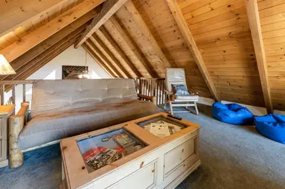 a bedroom with a bed and a table in a attic at Stimboli Lodge- Sleeps 16 with tons of games and fun in Oakhurst