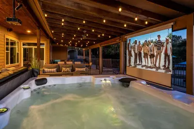 a jacuzzi tub in a house with a tv at Mountain Elegance w/ pool, spa, projector in Coarsegold