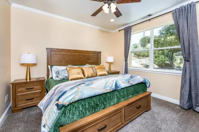 a bedroom with a bed and a window at Mountain Elegance w/ pool, spa, projector in Coarsegold