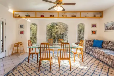 a living room with a couch and a table and chairs at Big Oak Manor w/theater/hot tub/sauna/more in Oakhurst