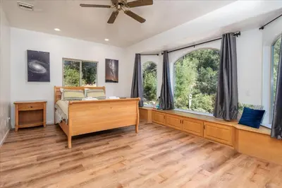 a bedroom with a bed and a large window at Big Oak Manor w/theater/hot tub/sauna/more in Oakhurst