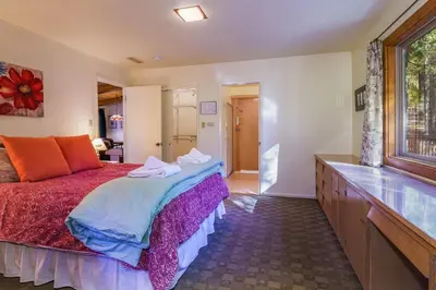 a bedroom with a large bed and a large window at Peace of Mine - Cabin inside Yosemite - Dog Friendly in South Wawona
