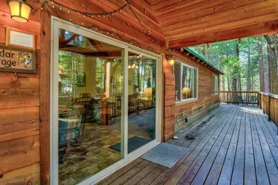 a front porch of a cabin with glass doors at Peace of Mine - Cabin inside Yosemite - Dog Friendly in South Wawona