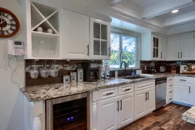a kitchen with white cabinets and marble counter tops at Doe Cabin Hot Tub/Playground/Game Room and more in Oakhurst