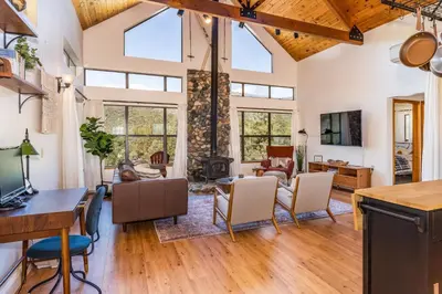 a living room with a table and chairs and a fireplace at Hilltop Haven- Bright and Modern Cabin w/ hot tub and stunning views in Oakhurst