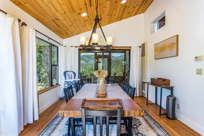 a dining room with a table and chairs at Hilltop Haven- Bright and Modern Cabin w/ hot tub and stunning views in Oakhurst