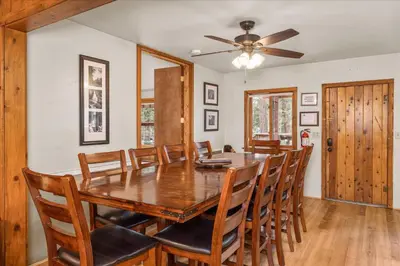 a dining room with a wooden table and chairs at Cub House- Remodeled cabin INSIDE Yosemite with new hot tub and more in North Wawona