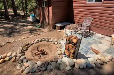 a fire pit in a yard next to a house at Beetlebark Bungalow- Inside Yosemite w/ hot tub EV charging cable in North Wawona