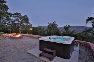 a large bath tub sitting on top of a patio at Canyon View House w/ hot tub, game room, views, and more in Oakhurst