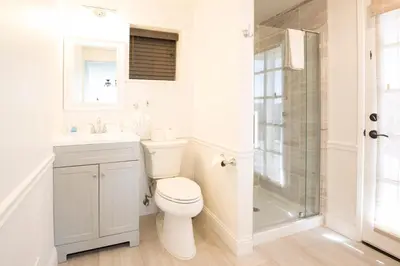 a white bathroom with a toilet and a shower at Canyon View House w/ hot tub, game room, views, and more in Oakhurst