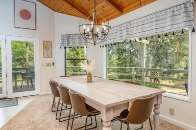 a dining room with a table and chairs and a chandelier at Hodges Hill Hideout w/ pool, spa, BBQ - Dog Friendly in Oakhurst