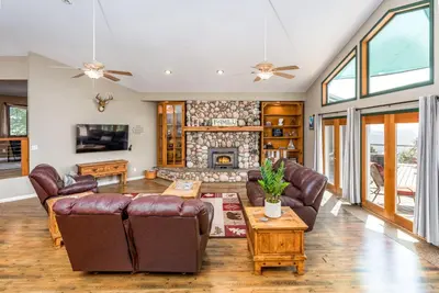 a living room with leather furniture and a fireplace at Skyline Lodge- amazing views w/spa/game room in Oakhurst