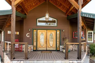 a wooden front door of a house with a porch at Skyline Lodge- amazing views w/spa/game room in Oakhurst