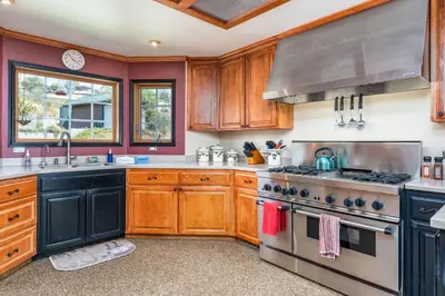 a kitchen with wooden cabinets and a stove top oven at Skyline Lodge- amazing views w/spa/game room in Oakhurst