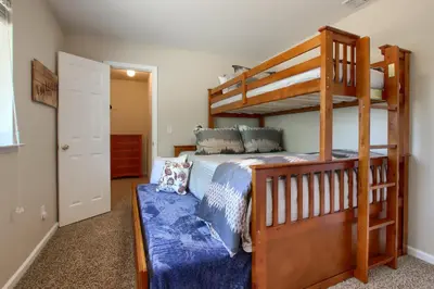 a bedroom with a bunk bed with a blue comforter at Scenic Serenity 50 acres/hot tub/game room in Oakhurst