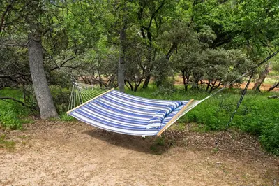 a blue and white hammock hanging from a tree at Scenic Serenity 50 acres/hot tub/game room in Oakhurst