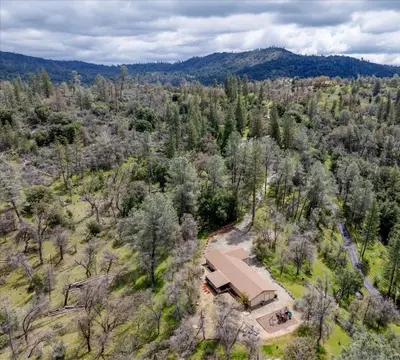 an aerial view of a house in the woods at Scenic Serenity 50 acres/hot tub/game room in Oakhurst