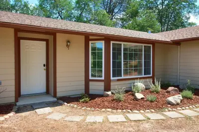 a home with a front door and a yard at Scenic Serenity 50 acres/hot tub/game room in Oakhurst