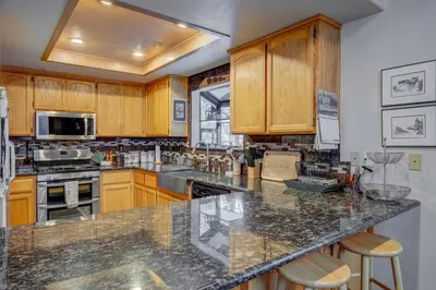 a kitchen with wooden cabinets and a granite counter top at Tahoe Donner Greenbelt Retreat in Truckee