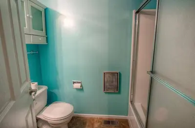 a blue bathroom with a toilet and a shower at Sugar PIne home in Incline Village