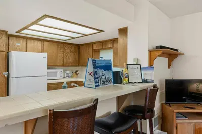 a kitchen with a counter with chairs and a white refrigerator at Heavenly Chairview Condo home in Stateline
