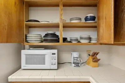a kitchen with a microwave and plates on shelves at Heavenly Chairview Condo home in Stateline