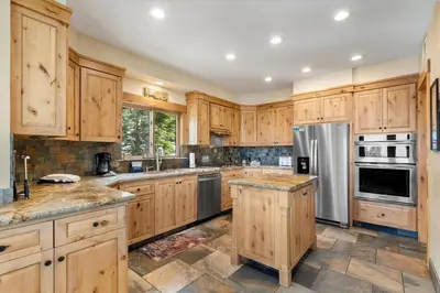 a kitchen with wooden cabinets and stainless steel appliances at Stage Coach Run home in Stateline