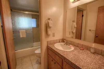 a bathroom with a sink and a toilet and a mirror at Foothill Folly home in Zephyr Cove