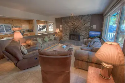 a living room with couches and a stone fireplace at Foothill Folly home in Zephyr Cove