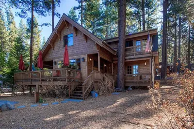 a large log cabin in the woods with trees at Smokey Joes cabin in Zephyr Cove