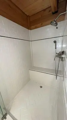a shower in a bathroom with white tiles at Smokey Joes cabin in Zephyr Cove