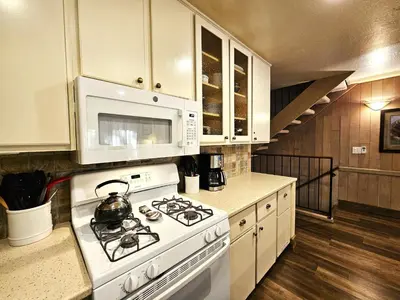 a white kitchen with a stove and a microwave at Cheyenne's Place home in Kings Beach